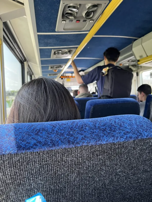 Second deck of busy GO bus with a standee in the aisle