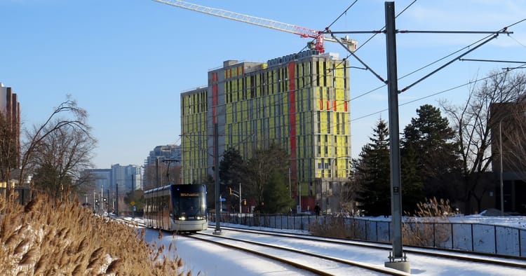 Tramway in dedicated rail corridor with snow on the ground.