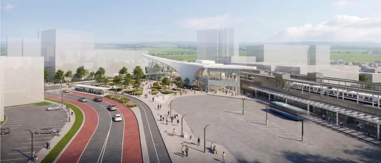 Train station with plaza in front and a bus loop. Victoria St has bus lanes and protected two-way bike lanes along the station.